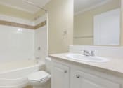 Thumbnail 14 of 24 - A white bathroom with a toilet, sink, and bathtub.