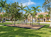 Thumbnail 25 of 29 - a park with palm trees in front of a building
