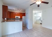 Thumbnail 10 of 29 - A kitchen with brown cabinets and a white counter.
