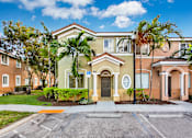 Thumbnail 26 of 29 - a house with palm trees and a sidewalk in front of it