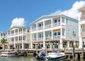 Thumbnail 11 of 20 - A row of houses are built on stilts over a body of water.