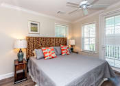 Thumbnail 8 of 20 - A bedroom with a bed, two lamps, and a ceiling fan.