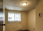 Thumbnail 9 of 17 - A room with a window covered by white blinds and a white radiator on the wall.