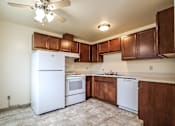 Thumbnail 8 of 17 - A kitchen with white appliances and brown cabinets.