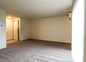 Thumbnail 7 of 17 - A room with a carpeted floor and a closed door.