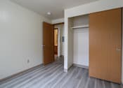 Thumbnail 5 of 17 - A hallway with two doors and a grey floor.