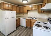 Thumbnail 3 of 17 - A white refrigerator is in a kitchen with wooden cabinets.