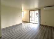 Thumbnail 4 of 17 - A room with a wooden floor and sliding glass doors.