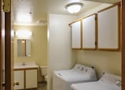 Thumbnail 8 of 15 - A bathroom with a toilet, sink, and mirror.
