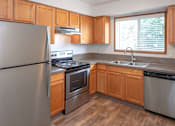 Thumbnail 1 of 16 - a kitchen with wooden cabinets and stainless steel appliances