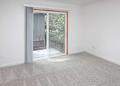 Thumbnail 4 of 16 - a bedroom with a sliding glass door and carpet