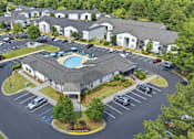 Thumbnail 1 of 41 - A large building with a pool in the middle of a parking lot.