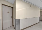 Thumbnail 22 of 28 - the hallway of a building with a door and a white wall