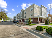 Thumbnail 6 of 26 - A parking lot in front of apartment buildings.
