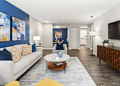 Thumbnail 3 of 41 - A living room with a white couch and a coffee table.