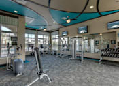 Thumbnail 29 of 40 - Free weights, benches, and other fitness equipment in fitness center at Lake Nona Water Mark in Orlando, FL 32827