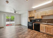 Thumbnail 12 of 26 - A kitchen with wooden cabinets and black appliances.