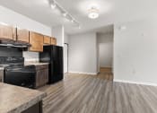 Thumbnail 2 of 24 - a River Flats kitchen with black appliances, wood-cabinets, and track lighting