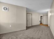 Thumbnail 16 of 28 - a living room with a white door and a carpeted floor