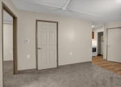 Thumbnail 4 of 28 - a living room with a white door and a door to a bedroom