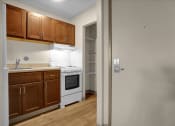 Thumbnail 18 of 28 - a kitchen with wooden cabinets and a white stove and refrigerator