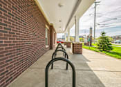 Thumbnail 4 of 26 - A long row of black bicycle racks are lined up on a sidewalk.
