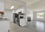 Thumbnail 3 of 18 - a large open living room with a vaulted ceiling and a renovated kitchen at Rock Creek Apartments