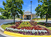 Thumbnail 7 of 41 - A flower bed in front of a building with the name "The Wellington" on it.