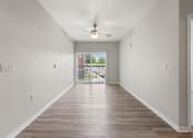 Thumbnail 4 of 24 - a large living room with wood-style flooring, a ceiling fan, and a large window