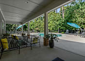 Thumbnail 20 of 28 - A patio with a table and chairs overlooking a pool.
