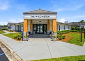 Thumbnail 8 of 41 - The Wellington building has a white and orange facade with a blue sign above the entrance.