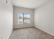 Thumbnail 6 of 24 - a bedroom with a large window filled with natural light in a home at River Flats Apartments