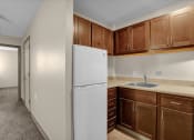 Thumbnail 11 of 28 - a kitchen with a white refrigerator and wooden cabinets