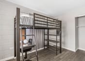 Thumbnail 9 of 37 - A room with a bunk bed and a desk.
