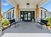 Thumbnail 9 of 41 - A building entrance with two benches on either side.