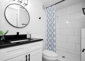 Thumbnail 7 of 29 - a bathroom with a sink and a mirror and a toilet