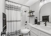 Thumbnail 2 of 37 - A white bathroom with a black and white shower curtain.