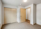 Thumbnail 22 of 26 - A room with a tan carpet and two wooden doors.