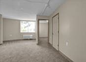 Thumbnail 17 of 28 - an empty living room with a white door and a window