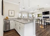 Thumbnail 14 of 41 - A modern kitchen with a granite countertop and stainless steel appliances.