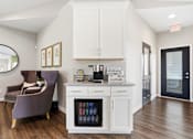 Thumbnail 15 of 41 - A kitchen with a purple chair and a fridge with a glass door.