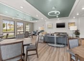 Thumbnail 16 of 24 - River Flats community room with tables, chairs, sofas, and TV