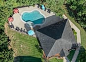 Thumbnail 1 of 28 - A backyard with a pool and a black tarp covering a structure.