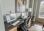 Thumbnail 2 of 26 - A modern home office with a large painting on the wall and a desk with a computer and printer.