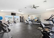 Thumbnail 16 of 41 - A spacious gym with a variety of equipment including treadmills, stationary bikes, and weight machines.