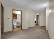 Thumbnail 3 of 28 - a living room with a door to a bathroom and a toilet