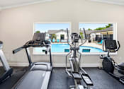Thumbnail 18 of 41 - A room with a treadmill, elliptical trainer and a stationary bike.