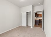 Thumbnail 7 of 24 - a bedroom with a sliding door closet and a door that opens into the kitchen