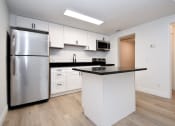 Thumbnail 9 of 36 - a kitchen with white cabinets and a stainless steel refrigerator