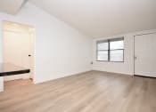 Thumbnail 10 of 36 - an empty living room with white walls and a window
